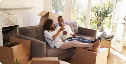 Young couple sitting on couch after unpacking in their new home